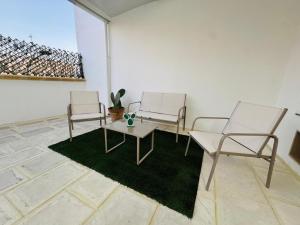 three chairs and a table in a room at PIAZZA COPERTA Casa Vacanza in Aradeo