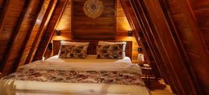 a bedroom with a bed with a wooden wall at D'Cabin Villa Uluwatu in Uluwatu +42 photos