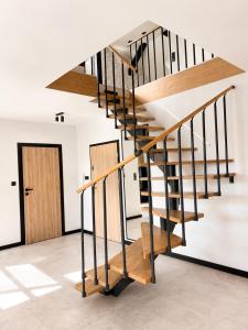 a wooden staircase in a room with a door at Apartament Niebo przy plaży ROYAL APARTS OSTRÓDA in Ostróda
