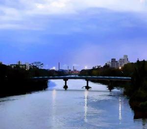 a bridge over a river with a city in the background at Apart Centro 06 in Tubarão