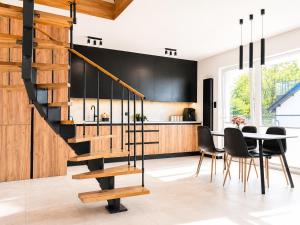 a kitchen and dining room with a staircase and a table at Apartament Niebo przy plaży ROYAL APARTS OSTRÓDA in Ostróda +40 photos