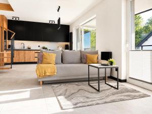 a living room with a couch and a table at Apartament Niebo przy plaży ROYAL APARTS OSTRÓDA in Ostróda