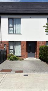 a brick house with a black door and windows at La Vio Homestay Private Room & Bathroom, Newcastle Dublin in Newcastle