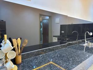 a kitchen with black granite counter tops and a mirror at Palm & Tide Kenitra Residence in Kenitra +21 photos