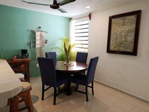 a dining room with a wooden table and blue chairs at Private House with Pool, 2 Bedrooms & Parking in Valladolid