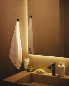 a bathroom sink with a mirror and a towel at A-Apartment in Gjakove +19 photos