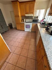 a kitchen with wooden cabinets and a tile floor at The Ardmore Home Share in Los Angeles +6 photos