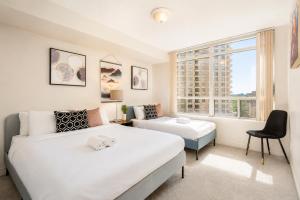 a bedroom with two beds and a window at High-End 2BR 2BATH Condo-Steps to Square One Mall in Mississauga