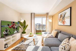 a living room with a couch and a tv at High-End 2BR 2BATH Condo-Steps to Square One Mall in Mississauga
