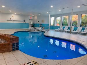 a large swimming pool in a large room with chairs at Hotel M Mount Pocono in Mount Pocono