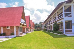 a row of buildings with a green yard at Hotel Ensueño del Bosque Valle de Bravo in Valle de Bravo