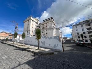 a street with two palm trees in front of a building at Suite Acogedora Centro de Tulcán in Tulcán