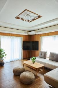 a living room with a couch and a table at Furano Lavender House helps guests book great restaurants in Furano in Furano