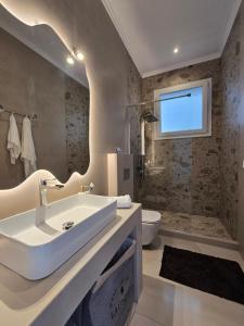 a bathroom with a sink and a toilet at Stone House with Panoramic Views in Marmaro in Mármaron +17 photos