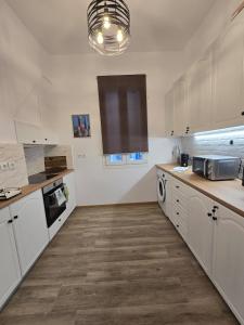 a kitchen with white cabinets and a counter top at Stone House with Panoramic Views in Marmaro in Mármaron