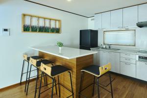 a kitchen with a island with bar stools at Furano Lavender House helps guests book great restaurants in Furano in Furano