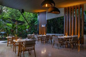 a dining room with tables and chairs and trees at Noah's Hideaway by Tifakara in Fortuna