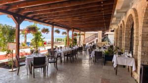 a restaurant with tables and chairs with a view at Hotel Biser in Kališta