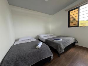 two beds in a room with a window at Altavista Cabin Rest House in Barbosa