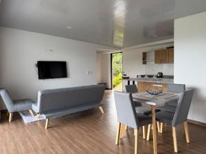 a living room with a couch and a table with chairs at Altavista Cabin Rest House in Barbosa