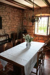a dining room table with a vase of flowers on it at House Kisic in Višnjan