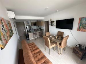 a living room with a table and a couch at Loft Apartment - Full AC With Free Parking Pool in Cartagena de Indias