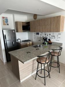 a kitchen with a counter and two bar stools at Loft Apartment - Full AC With Free Parking Pool in Cartagena de Indias