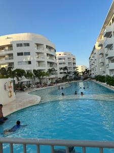 a large swimming pool with people in the water at Loft Apartment - Full AC With Free Parking Pool in Cartagena de Indias
