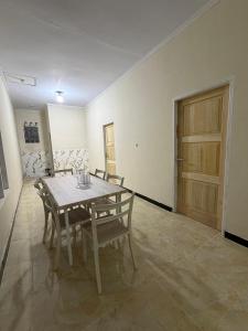 a dining room with a table and chairs and a door at Homestay Whale Shark in Pohe