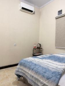 a bedroom with a bed and a air conditioner on the wall at Homestay Whale Shark in Pohe +2 photos