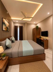 a bedroom with a bed with a ceiling fan and a desk at Hotel Golden Glory Scheme 103 in Indore