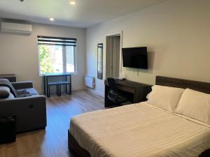 a bedroom with a bed and a desk and a television at Complexe la Falaise in Rivière-du-Loup
