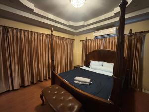 a bedroom with a canopy bed and a chair at Aonang Poonsiri Cozy Villa in Ban Khlong Haeng