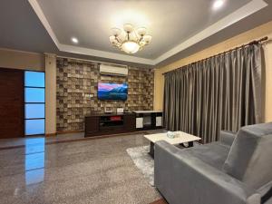 a living room with a couch and a tv at Aonang Poonsiri Cozy Villa in Ban Khlong Haeng