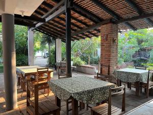 a patio with tables and chairs under a pavilion at Hotel Verdemar in Acapulco