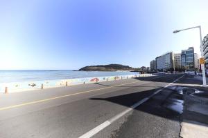 an empty street next to a beach with buildings at Hamduk Pungkyungchae Pension in Jeju