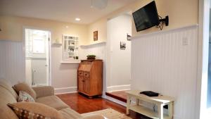 a living room with a couch and a tv on a wall at Lakeview Retreat in Cape May Point