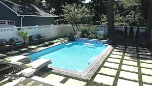 a swimming pool in a yard with a fence at West Cape Oasis in West Cape May