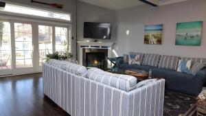 a living room with four white couches and a fireplace at West Cape Oasis in West Cape May