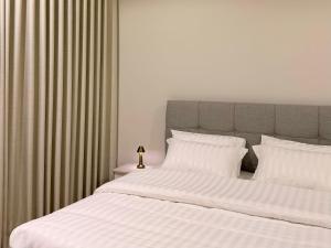 a bedroom with a large bed with white sheets and pillows at وسط المدينة للشقق السكنيه in Medina