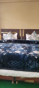 a bed with a blue blanket and pillows on it at Ochre Spiti in Lara +7 photos