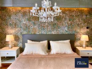 a bedroom with a large bed with a chandelier at Hotel IL MULINO - Colazione a Buffet e Parcheggio Privato in Casalgrande