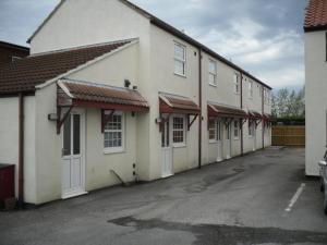 una fila de edificios blancos en un estacionamiento en Vale of York, en Thirsk