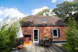 a small brick house with a wooden deck at Melkerhaus in Loit