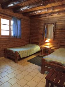 a log cabin with two beds and a mirror at Cabañas La Brama in Aluminé