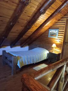 a bedroom with a bed in a log cabin at Cabañas La Brama in Aluminé