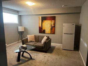 a living room with a couch and a refrigerator at Cozy private basement suite with separate entrance in Calgary