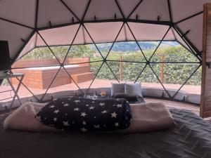 a large bed in a room with a large window at Glamping oriente antioqueño in San Vicente