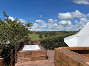 a wooden deck with a hot tub and a tent at Glamping oriente antioqueño in San Vicente