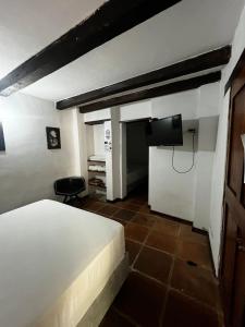 a bedroom with a bed and a tv on the wall at Hotel Terraza San Antonio in Cali